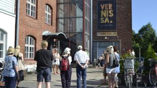 Opas puhuu historiakävelyn osallistujille Vernissan edustalla.